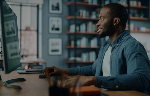 Handsome Black African American Specialist Working on Desktop Computer in Creative Home Living Room. Freelance Male is Working on a Finance Presentation Report for Clients and Employer