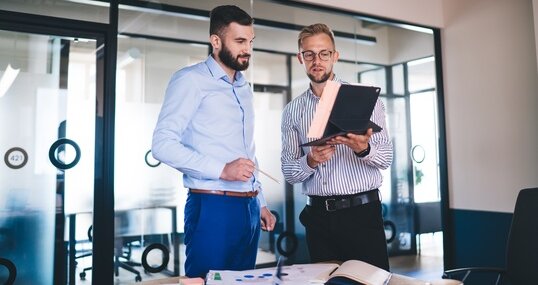 AdobeStock, zwei Männer im Büro im Austausch